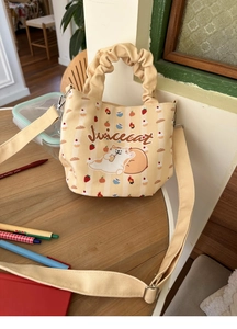 Detail of canvas bucket bag with ruffled handle, cat print and adjustable strap