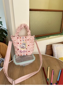 Close-up of pink striped canvas bucket bag featuring a cute rabbit and dessert print