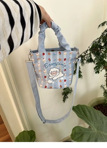 Detail of blue striped canvas bag with cute sheep design and detachable shoulder strap