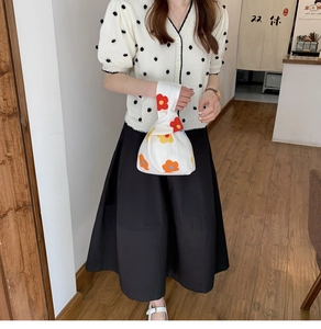 Japanese style floral wrist bag paired with a polka dot cardigan and black skirt