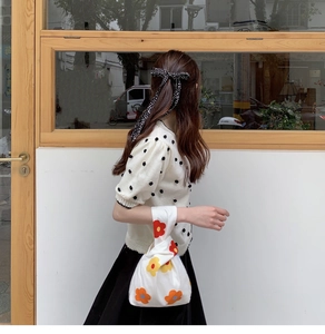 Japanese knot bag with floral print styled with a cream polka dot knit top and skirt