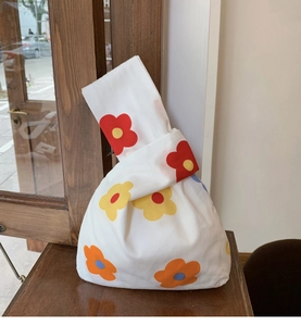 Detail of Japanese style floral knot wrist bag on wooden table with natural lighting
