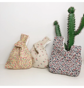 Detailed view of Japanese style knot wrist bags with floral and cherry cotton patterns