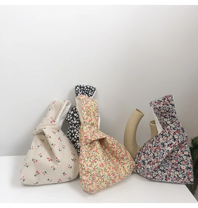 Detail of four Japanese knot bags with cherry and floral patterns on minimalist background