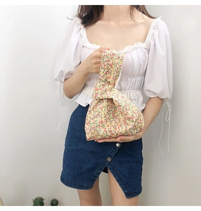 Close-up of Japanese style floral wrist bag with unique knot handle design and cotton fabric