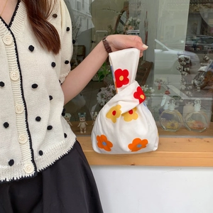 Japanese knot wrist bag with large floral print in red and yellow cotton fabric