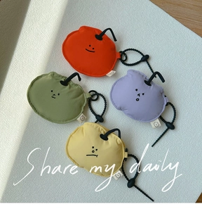 Flat lay of colorful fruit-shaped earphone pouches with adjustable drawstrings