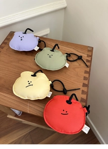 Close-up of colorful mini storage pouches in purple, green, yellow, and red on wood