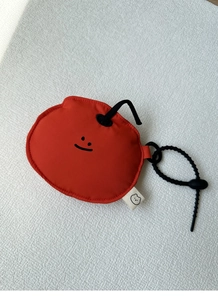 Detailed view of a red fruit-shaped mini earphone pouch with adjustable black lanyard