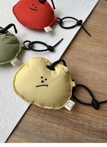 Macro detail of soft fruit-shaped earbuds cases with cute expressions and elastic lanyards