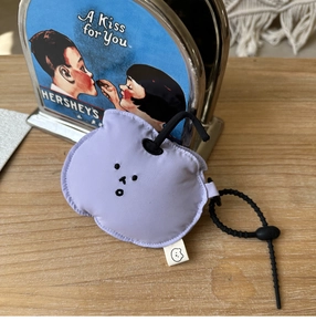 Detail of light purple quilted earphone pouch with embroidery and black lanyard