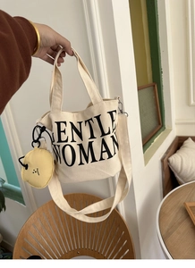 Close-up of Gentlewoman canvas tote with yellow smiley face pouch and crossbody strap