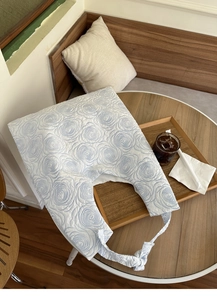 Detail view of 3D embossed floral patterns on a light blue canvas tote bag with knot straps