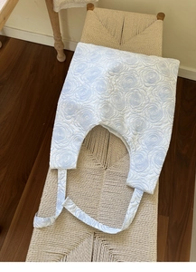 Detail of the embossed blue floral pattern and 3D textured fabric on a white tote bag