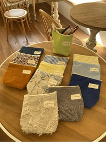 Detailopname van diverse stoffen cosmetische tassen met bloemen- en ruitpatroon op houten tafel
