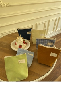 Detail van kleurrijke mini make-up tasjes van corduroy en canvas met stoffen labels