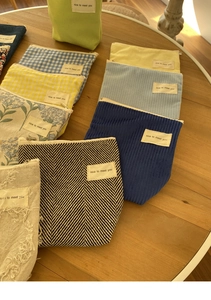 Detailopname van kleurrijke mini-make-uptasjes van corduroy en canvas op houten tafel