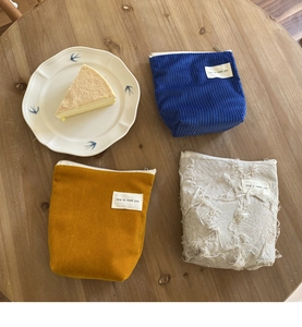 Detail van gestructureerde corduroy en canvas mini make-up tasjes met franjes en label
