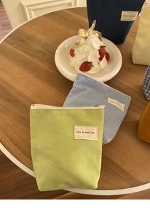 Detailopname van draagbare make-uptasjes van canvas en corduroy met stoffen label