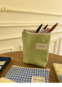 Close-up van minimalistische canvas tasjes met metalen ritsen en geweven labels