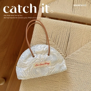 Floral relief canvas tote bag with 3D blue roses and leather handles on a beige chair