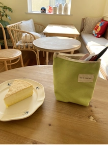 Mini groene canvas organizer tas met label en kantoorschrijfwaren pennen aan de binnenkant