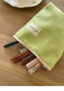 Macro-opname van een lichtgroene canvas etui met ritssluiting en een tekstlabel