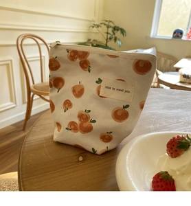 Mini canvas tasje met perzikpatroon en nice to meet you label op een houten tafel