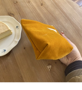 Detail van een gembergele fluwelen make-uptas op een houten tafel met zachte textuur