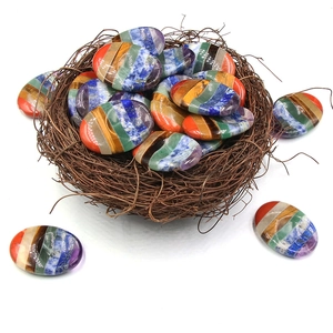 Set di pietre chakra con cristalli a strisce colorate in un decoro a nido d'uccello naturale
