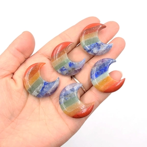 Pendentifs lune en pierre naturelle aux sept couleurs de chakra présentés dans la main