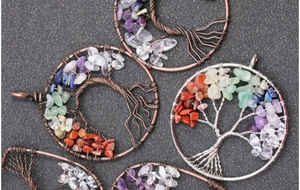 Close-up of handmade tree of life pendants with colorful natural crystal stones