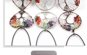 Close-up of handmade copper wire tree of life pendants with colorful natural stone chips