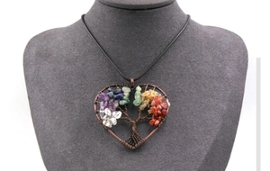Detail of handmade bronze wire wrapped tree of life heart pendant with colorful crystals