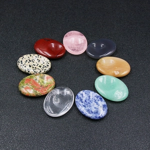 Nueve piedras de cristal natural ovaladas y pulidas para masaje facial gua sha en fondo oscuro