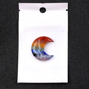 Detail view of crescent moon shaped chakra stone with vibrant seven color stripes