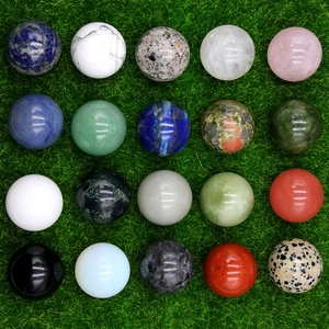 Polished 30mm natural gemstone balls set including rose quartz and aventurine on green grass