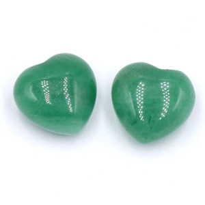 Pierres naturelles en cristal vert en forme de cœur polies sur un fond blanc neutre