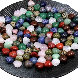 Pierres de cristal naturel polies en forme de cœur de couleurs variées sur un plateau