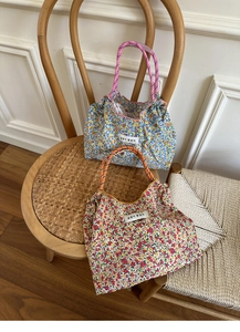 Macro detail of floral canvas tote bags with woven rope handles and fabric labels