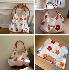 Detail of floral canvas tote bag with braided handles and pink overlock stitching detail