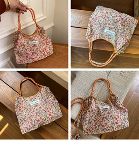 Detail of floral canvas tote bag featuring orange rope handles and forest label