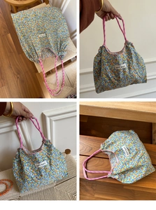 Close-up of floral canvas tote bag with woven pink rope handles and Korean label
