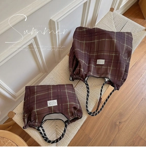 Detail of vintage brown plaid canvas bag with braided rope handle and minimalist woven label