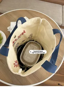 Spacious interior of canvas lunch bag showing a 16x11.5x7.5cm metal box with embroidery