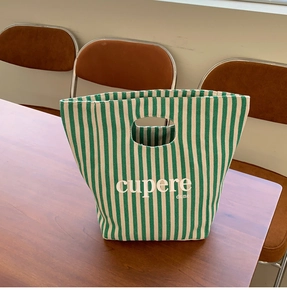Dettaglio della borsa in tela a righe bianche e verdi con manico tondo e logo stampato