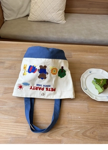 Detail of color-block canvas lunch bag with cartoon animal embroidery and metal clasp