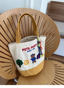 Canvas lunch bag with PETS PARTY cartoon animal embroidery on a wooden chair