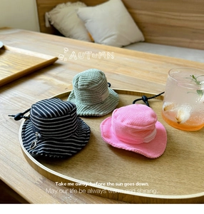 Close-up of mini bucket hat earphone cases in corduroy fabric with adjustable drawstrings