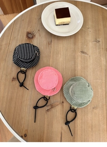 Detailed macro view of mini hat-shaped pouches with corduroy texture and metal zippers